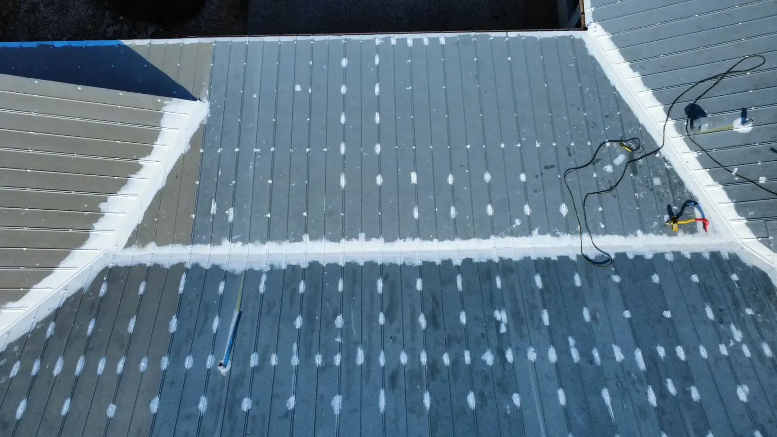 During: seam sealing and elastomeric base coat on a metal roof — PowerHouse Roof Restoration, San Antonio, Texas